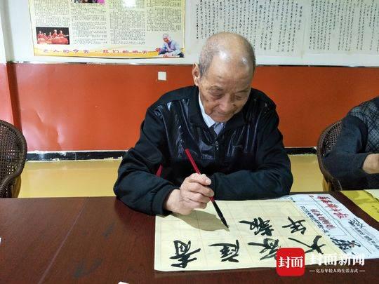 张宗儒老人写下“大家庭青年报”几个字。